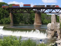 One of CN's last and first DC models built by General Electric roll intermodal train #148 high above the fishermen and the unique "S" shape dam along the Grand River at Paris.
