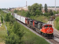 The heat and humidity is no factor for the crew of not so common train 523. The train has just crossed Bronte Creek on the single track bridge at Tansley in the distance. To the right is the brick works facility, which from time to time still sends out boxcar loads from the loading dock to the right. On this day CN had MofW equipment stored on the stub track. 