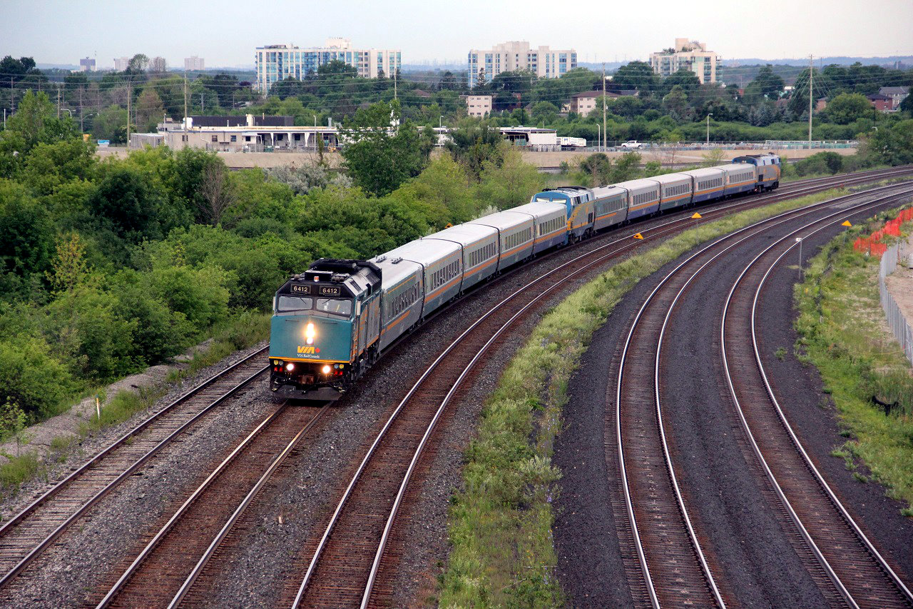 Around 715 AM on Canada Day, Via 6412 train number unknown , rounds the curve at Whitby east bound. With more Via trains having units at both ends and combining two trains, one has to wonder about the efficiency of a train like this. 11000 hp ? Can anybody shed a little knowledge on the EB?