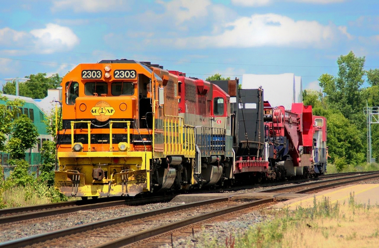 Having arrived at Georgetown, GEXR 516 with a special dimensional load from Babcox-Wilcox in Cambridge suns itself on the north track while waiting for a pair of other trains (CN 148 and GEXR 431) to slowly roll past with a 10 MPH restriction passing the dimensional car. After those two trains pass, the Goderich-Exeter power will uncouple and clear the junction at Silver, and the CN power that has just sitting there waiting for the last two hours just west of the junction will come in and couple on to the train and take over for the trip to Hamilton.