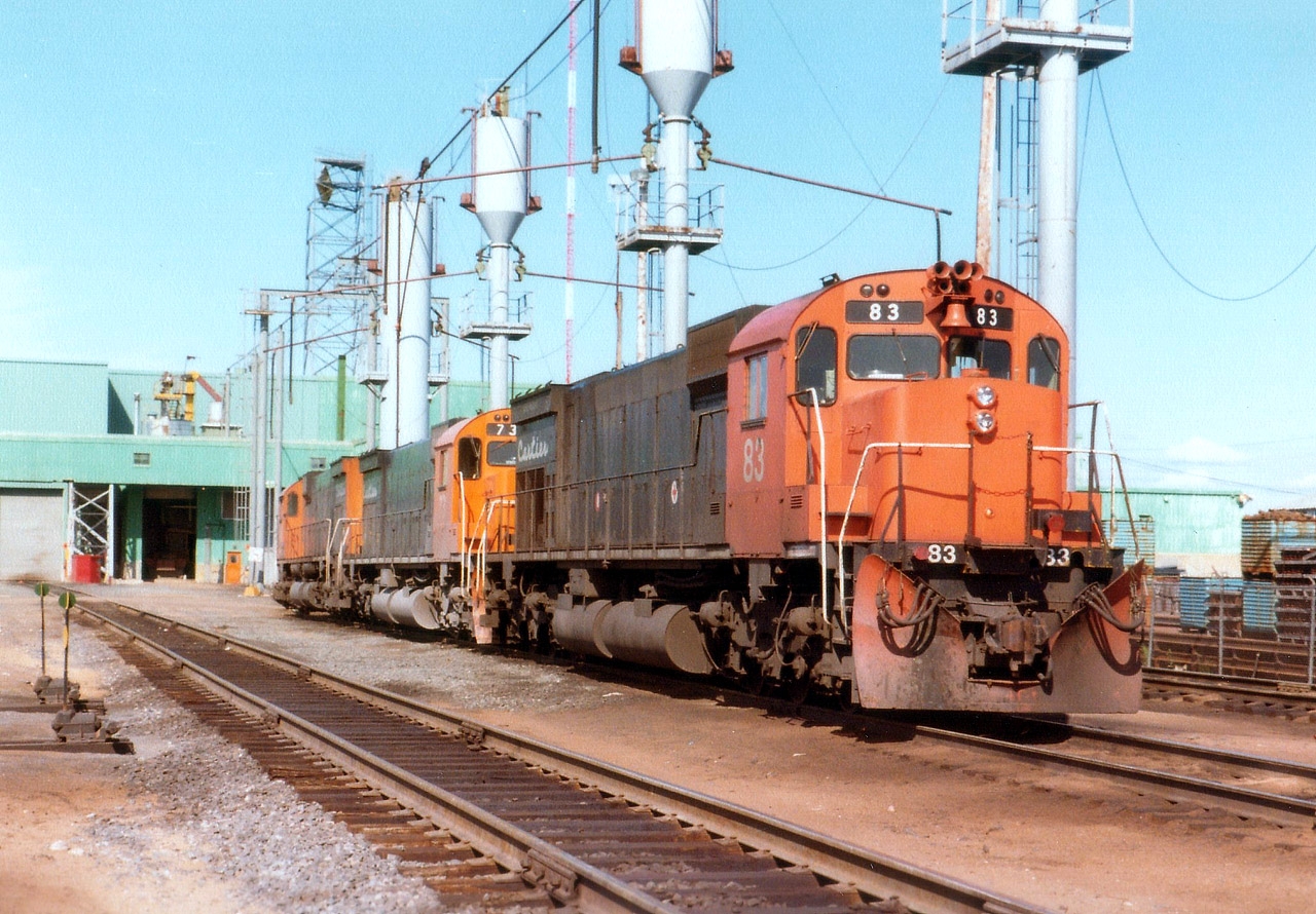 Back in the confines of the big sprawling iron ore complex at Port Cartier are seen a trio of MLW M-636s: Cartier 83, 73 and 45 at the locomotive servicing area. The 83 was scrapped 2011, 73 sold for scrap 2011, and the 45, which was x-CN 2304, was retired 2002 and sold. It currently lives as WNYP (Western NY and PA) #636.
 Cartier Railway is now known as ArcelorMittal Mines Canada.