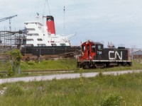 CN 7168, the resident switcher out of Merritton back at this time, runs back in the Port Weller Drydocks to fetch a couple of freight cars. The unit is just about to enter the fenced off area seen at the left of the photo. Ship under repair in background not identified other than it is part of the Algoma fleet. After CN gave up the industrial trackage in St. Catharines to Port Colborne Harbour (Trillium) in the late 1990s/early 2000s, the spur line north of the QEW was removed in stages, and now only runs as far as Bunting Rd and Eastchester, stopping just short of going under the QEW's Garden City Skyway. CN 7168 was one of the SW8s on the roster, of which all were retired by 1989.
