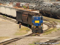 A former Raillink engine, still in it's previous owner's colors..pull a string of cars out of a siding at the old Stuart Street yard. The conductor is alongside the train, and will throw the switch once it has cleared.