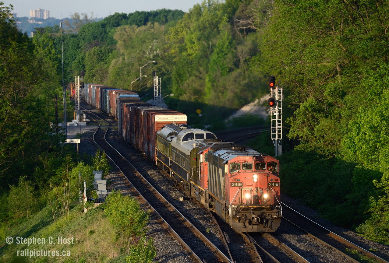 Another case of the early bird gets the worm. At what time does the light hit the rails at Bayview Junction? This is when you should plan to arrive by, just before so you can set up in case something is close. And on this day, only  Bill Miller  and I were there to witness whatever was coming - hoping to see the business train cars on 422 later in the morning - little did we know what was coming.

Upon arrival at the crack of dawn we were met with  an eastbound lined through Bayview from Hamilton, being this early we did not know what to expect. As the train approached all you could hear was the familiar growling of an EMD 16 cylinder 567 as the train pulled a hundred plus cars through the grade out of Hamilton Yard. Then the business cars were seen behind the power - suprise ! - out of the shadow into the beautiful early morning light -. Click! The time is 0628 and light has been on the rails for 10 minutes.