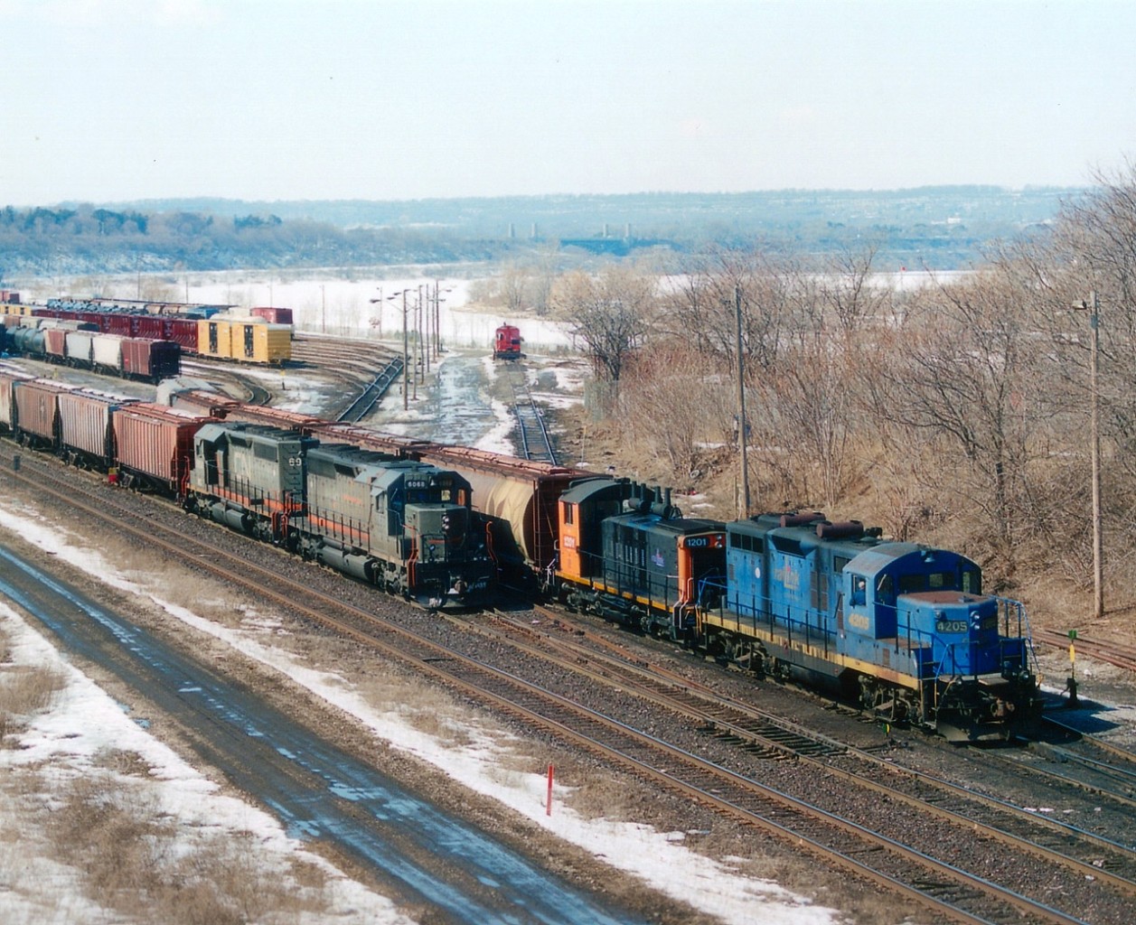 Side by side: RLK 4205 and 1201 at work in the former CN (now SOR) Stuart St yard alongside Niagara-bound CN train GCFX 6068 and WC 6934. Confusion abound (for me, anyway)at this time as old CN SD40s were being upgraded to SD40-3 and the transition from CN to Alsthom to Wisconsin Central ID was erratic.  These two units were former CN 5112 and 5146. Renumbered and upgraded when GEC Alsthom gray (owned by Connell Finance) to GCFX 6064 and 6068. THEN they were relettered to Wisconsin Central as 6934 and 6938.......but, at the time of this photo the 6068 has not yet been relettered/renumbered. The RLK? Well, 4205 was scrapped in 2008 and the 1201 has gone to an industrial park in Sarnia, ON.