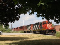 The temperature with the humidity is sitting around 38 degrees. There is little the crew of train 551 can do but open every possible door and window on their veteran GP9RM just to catch whatever breeze maybe outside the cab. I've taken to the shade of the few trees nearby as the crew switches out the lumber yard on the old Townline spur, which is all that remains of the original North & Northwestern Railroad line through town. The line was rebuilt with a grade separation through Milton in 1960 when CN's Toronto's Mac Millian yard opened north of the city.