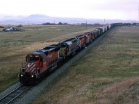 I just graduated, and we were on a road trip that would take us to the west coast, all the way to California, and then back up through the national Parks of Arizona, Utah and Wyoming.
We caught this westbound manifest west of Cowley. Note the leased Algoma Central SD-40.