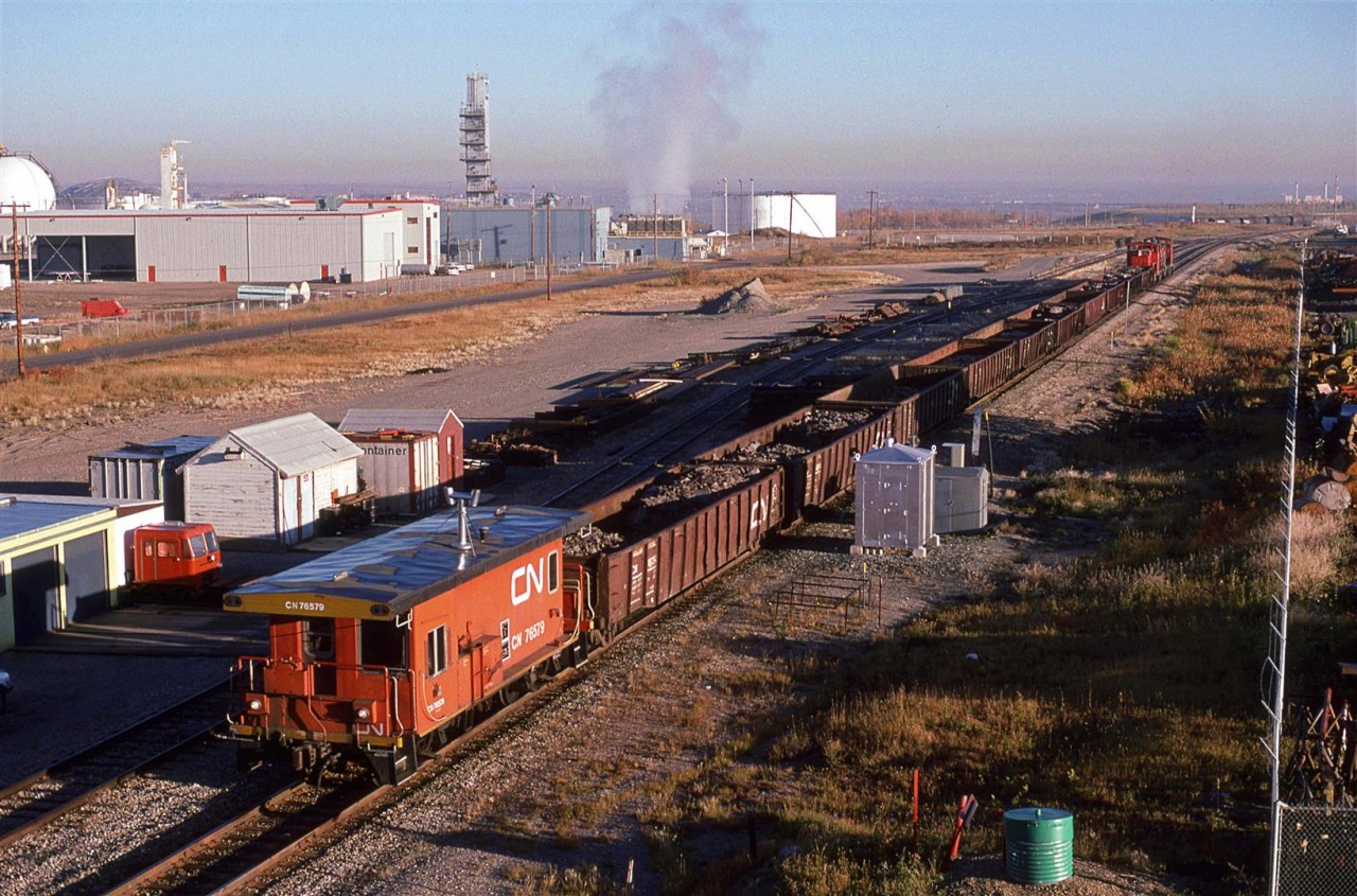This Work Extra is backing down the Camrose Sub.
Esso's refinery complex is to the left. In the upper righ corner, Edmonton Power's power plant may be seen.
Note the speeder at left.
If you look really carefully, and us a little imagination, the Wainwright Sub bridge over the North Saskatchewan River may be seen slightly to the left and above the locomotives.