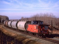 #759, a loaded potash train, rounds the curve that brings the Edson Sub back to a westerly direction.
According to the map that I had been using at the time, there used to be a bridge over the tracks for the township road where I am standing. By 1988, it had been removed and the road dead-ended at the tracks. Trevor S has a drone view looking the other way.
https://www.flickr.com/photos/66869919@N04/20588377359/in/dateposted/