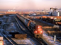 It is hard to believe that it is almost 10 am, but this is what you get at latitude 53.
We have a southbound empty grain train on the Camrose Sub in east Edmonton. #820 was a fairly common train, therefore, i am led to believe that it dealt with elevator on the Camrose and Three Hills Sub's between Edmonton and Calgary. Other options south of Edmonton seem unlikely. The Alliance Sub (SE of Carmose) and the Brazeau Sub (West at Mirror) did not seem to have that many grain facilities to account for all the #820's that I would see.
The power seems a little strange for a secondary mainline train. We have two high-nosed GP-9's leading - one still in NAR colours. Had I been able to drive, or if my wife was there, this would have been a fantastic train to chase. That wasn't going to happen on my bicycle.