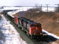 Range Road 224, east of Edmonton, was one of the very few places where there was an overpass for a non-highway. That made it much more pleasant for hanging around (Also, back then, nobody called you in for suspicious activity).
This eastbound auto train is a mystery to me. It might be #164, but it is more likely #204 - a train that I heard on the radio a few times.
Downtown Edmonton can be seen at right and the horizon now has urban sprawl across it.
