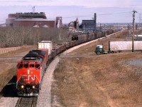 Here, we have the daily train from Edmonton to Calgary on the Camrose Sub in eastern Edmonton.
This train has the usual few TOFC/COFC up front. Next there are several dozen cars of ore concentrate that came in from Hay River, I believe, that is destined to be smelted at Trail BC. After that is the regular freight - mostly in box cars (wood products?).
The Stelco steel plant is prominent in the background and truck fanatics might find the vehicle on the right interesting.