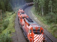 In order to show my railfan acquaintance how one can chase a train from the summit of Kicking Horse Pass all the way to Golden - the area covered by his planned guide, we decided to chase this train. The next several photos were all taken from roadside locations. This was our seventh photo location, near the eastern end of Leanchoil Siding as the tracks pass under the highway, again. And, as is often the case, the weather was quite variable. There are not that many photo opportunities for the next few miles until the highway, railway and Kicking Horse River get constricted at Glenogle.