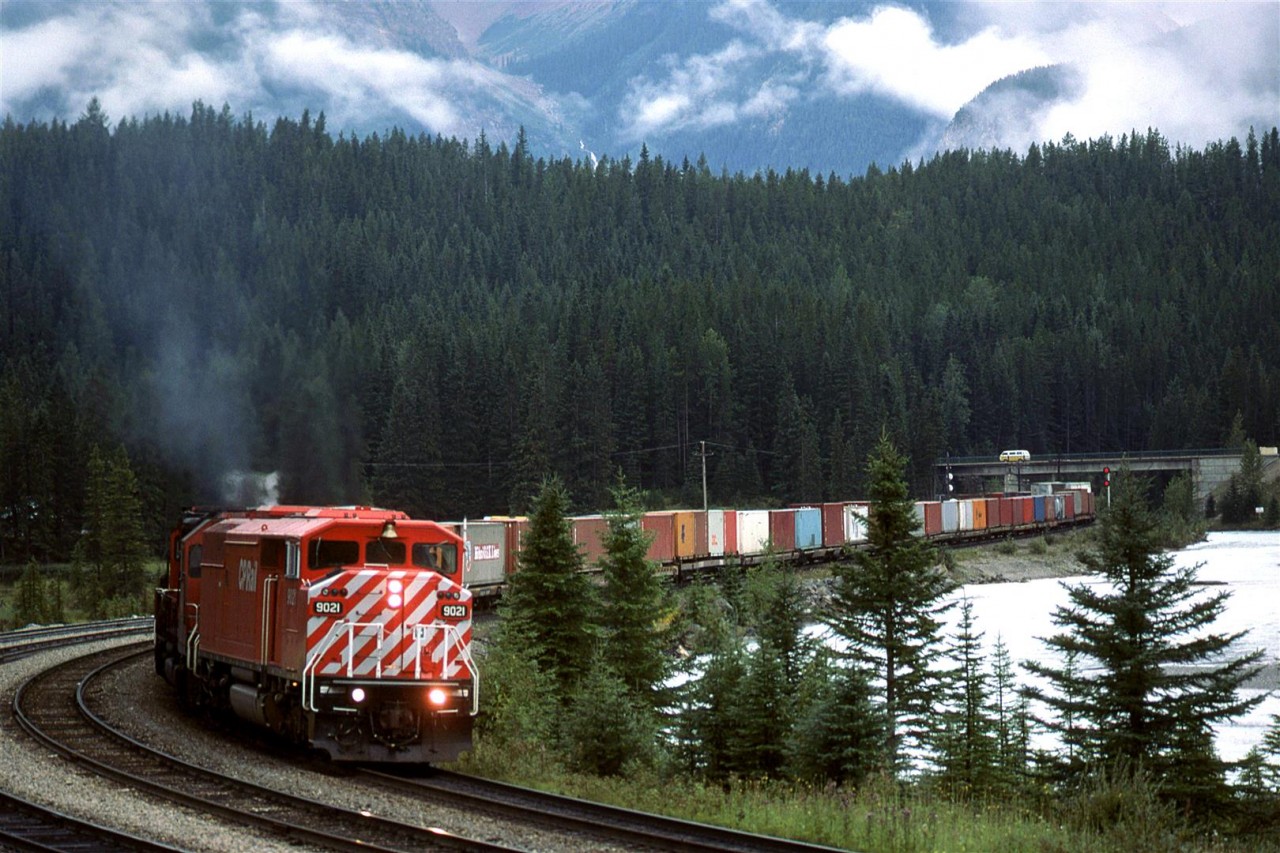 We finally caught a SD40-2F leading, and it looks like a high priority train. Not a box car, nor a grain hopper to be seen, although I do not recall what was on the rear of this train.
It is entering the yard from the west at Field.
Note the VW Microbus on the highway.