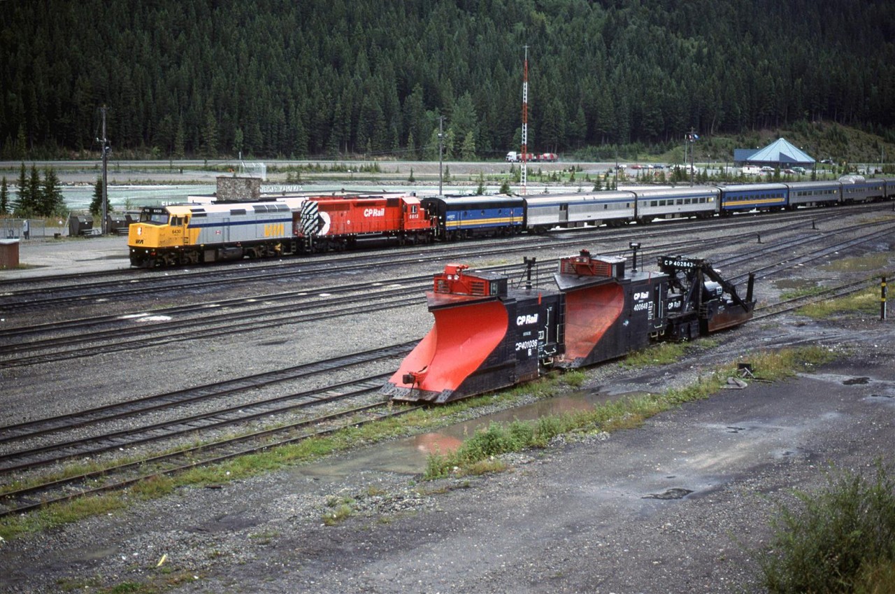 The lead units of the westbound "Canadian" block the depot at Field. Snow removal equipment waits for another season. 
The blue roofed building in the background is the Yoho National Park Visitor Center.