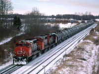 Although I did not hear it on the radio, I am virtually certain that this is train #218. The Tank cars and auto racks are pretty much a dead giveaway. 
Carvel is an interesting spot in that there is a large, relatively tight S curve in the tracks, some useful topography and nice scenery. On top of that, it is less than an hour outside Edmonton. This view is from the highway bridge, looking west. The train is wrapped around the curve to the south. Just out of frame, the curve reverses and the tracks continue west.