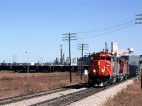 This empty Sulphur train is rounding the wye at Brettville Junction to head south down the Camrose Sub. At Alex Junction, it will go west on the Brazeau Sub to the sour gas fields near Rocky Mountain House for loading.
In the background is the Celanese chemical plant and Edmonton Power's generating plant (both now razed).