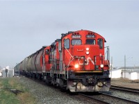 520 rolls out of Calder/Walker Yard in Edmonton and down the Wainwright Sub, toward Bretville Junction, where it will veer right down the Camrose Sub. It has grain empties for the elevators along the way and center beam lumber cars for a mill in Camrose.
The buildings to the right were for the stockyards that thrived at one time in NE Edmonton.
And the haze is likely smoke that blew in from forest fires.