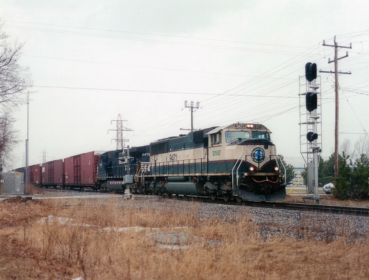 The NS autoparts train #328 once again outdid itself with its' remarkable variety of power. Seen on this morning roaring thru the Nelles Rd crossing at Grimsby is a seldom-seen (in Ontario) BNSF paint scheme from the early '90s.   I've always considered demise of this train the single biggest loss in my railfanning history around these parts. The train could feature anything up front.......whatever was available. Todays head end features BNSF 9471 and NS 9476. This is as close as I got catching two roads with the same unit numbers.......