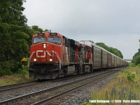 On a weird day weather wise, standing at a private driveway crossing in the rain...CN 2262 leads the charge of auto racks westbound past the yellow 'Paris West' sign (just to the left of the locomotive). 