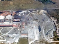 Out flying with a friend offered this aerial view of the Cooksville Brick Company's plant and quarry pit in Cooksville in 1953 (by then part of Toronto Township, the present-day Mississauga). CP's Galt Sub mainline runs along the north end of the property, and Dundas (Highway 5) runs along the bottom out of view. The area northwest of Cooksville where the plant was situated was still relatively rural. At one time, Cooksville Brick was once the largest manufacturer of bricks in Canada, and there was another pit located just to the west on the property (out of frame) near the corner of Mavis and Dundas.<br><br>Dump cars filled with excavated quarry material are visible on sidings between the plant buildings, and 40' boxcars with their doors open and loaded with brick sit on sidings just south of the Galt Sub. Quarry trackage can faintly be traced in the pit, but for a better view see: <a href=http://www.railpictures.ca/?attachment_id=25546><b>http://www.railpictures.ca/?attachment_id=25546</b></a>. Even one of Cooksville Brick's little black 0-4-0T switchers can be faintly spotted (at the north end, just south of the Galt Sub).