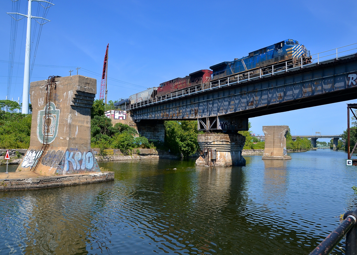 Over a locked swing bridge. CEFX 1002 & CP 8501 lead loaded ethanol train CP 650 over the Lachine Canal. They are passing over what is a swing bridge that is now locked in place, as commercial boat traffic has not used this portion of the canal since the 1970's.