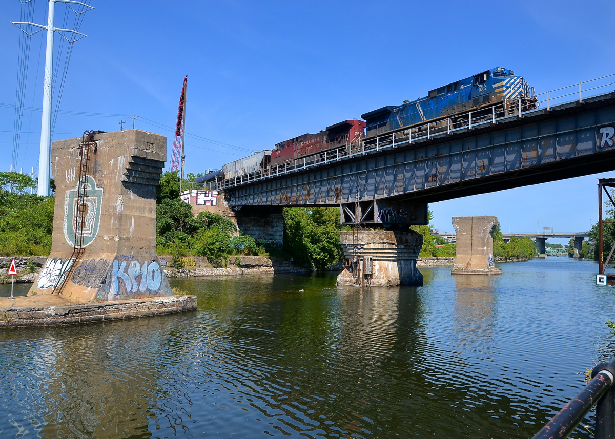 Over a locked swing bridge. CEFX 1002 & CP 8501 lead loaded ethanol train CP 650 over the Lachine Canal. They are passing over what is a swing bridge that is now locked in place, as commercial boat traffic has not used this portion of the canal since the 1970's.