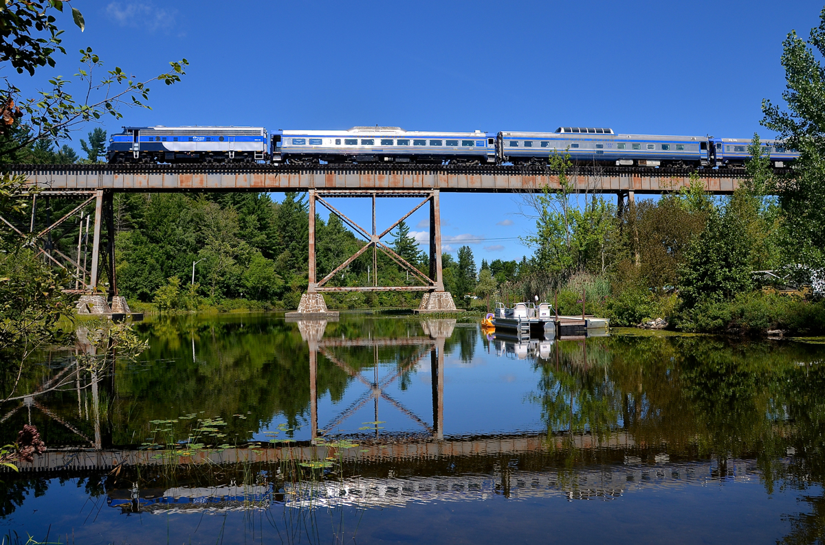 Back in business, and reflected. After not running during 2014 or 2015 (because one their dome car caught fire), the Orford Express has been running this summer. I finally got a chance to shoot it today at a classic location (the Eastman trestle) for the first time since 2013. Here the train is reflected in Lac d'Argent with FL9 OEXX 484 leading a 3 car train westwards over the trestle. In a minute the crew will change ends and the train will head east towards Sherbrooke.