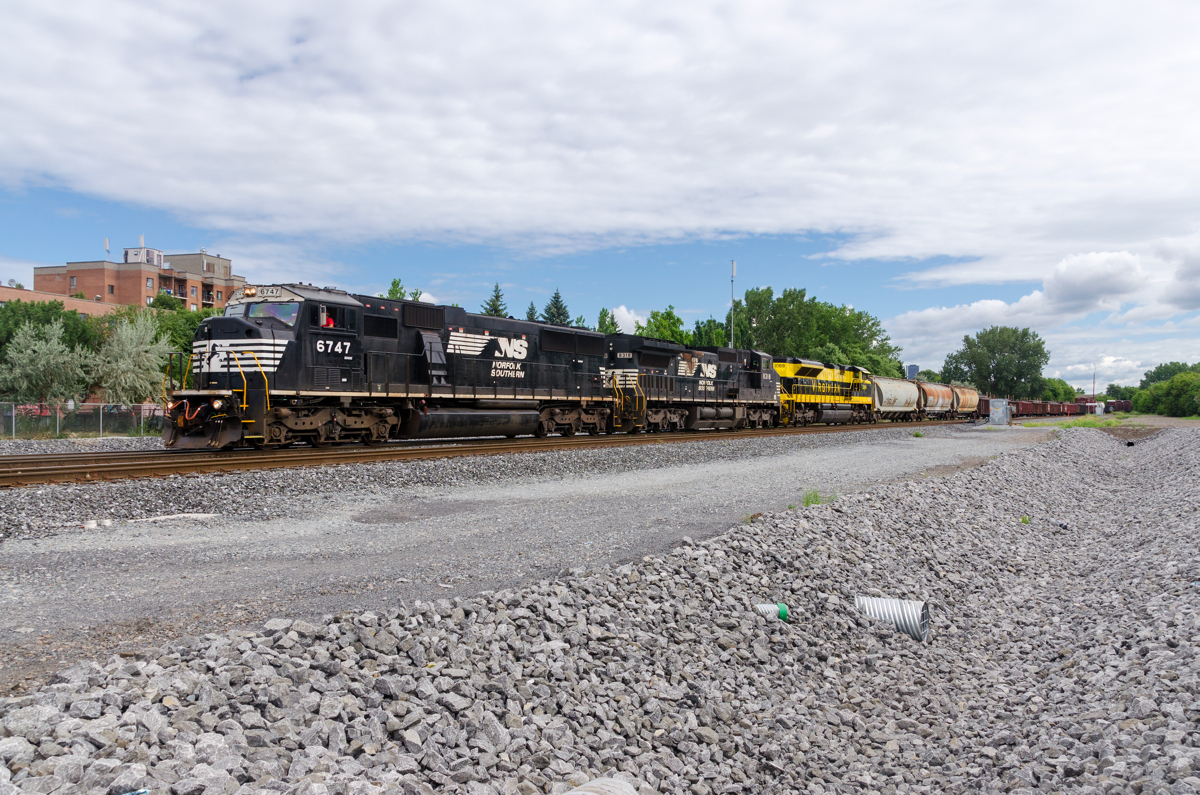 NS 6747, NS 8318 & heritage unit NS 1069 lead CN 529 through the St-Henri neighbourhood of Montreal.