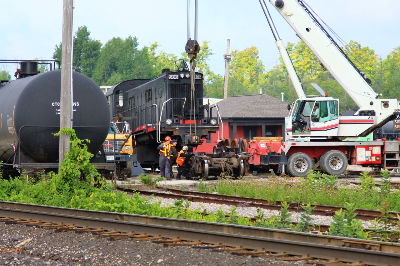 Built in 1959, Guelph Junction Railway  MLW RS-23 #506 sits in Guelph Junction with its nose lifted by the crane as the crew rolls out the old set of axels and truck in preparation for a new set.