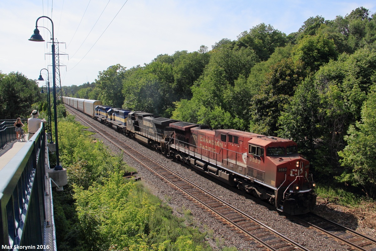 Canadian Pacific train 242 throttles up after the 10mph speed restriction at the Howland Crossover on the final leg of its journey to Toronto Yard with a rainbow consist following behind.