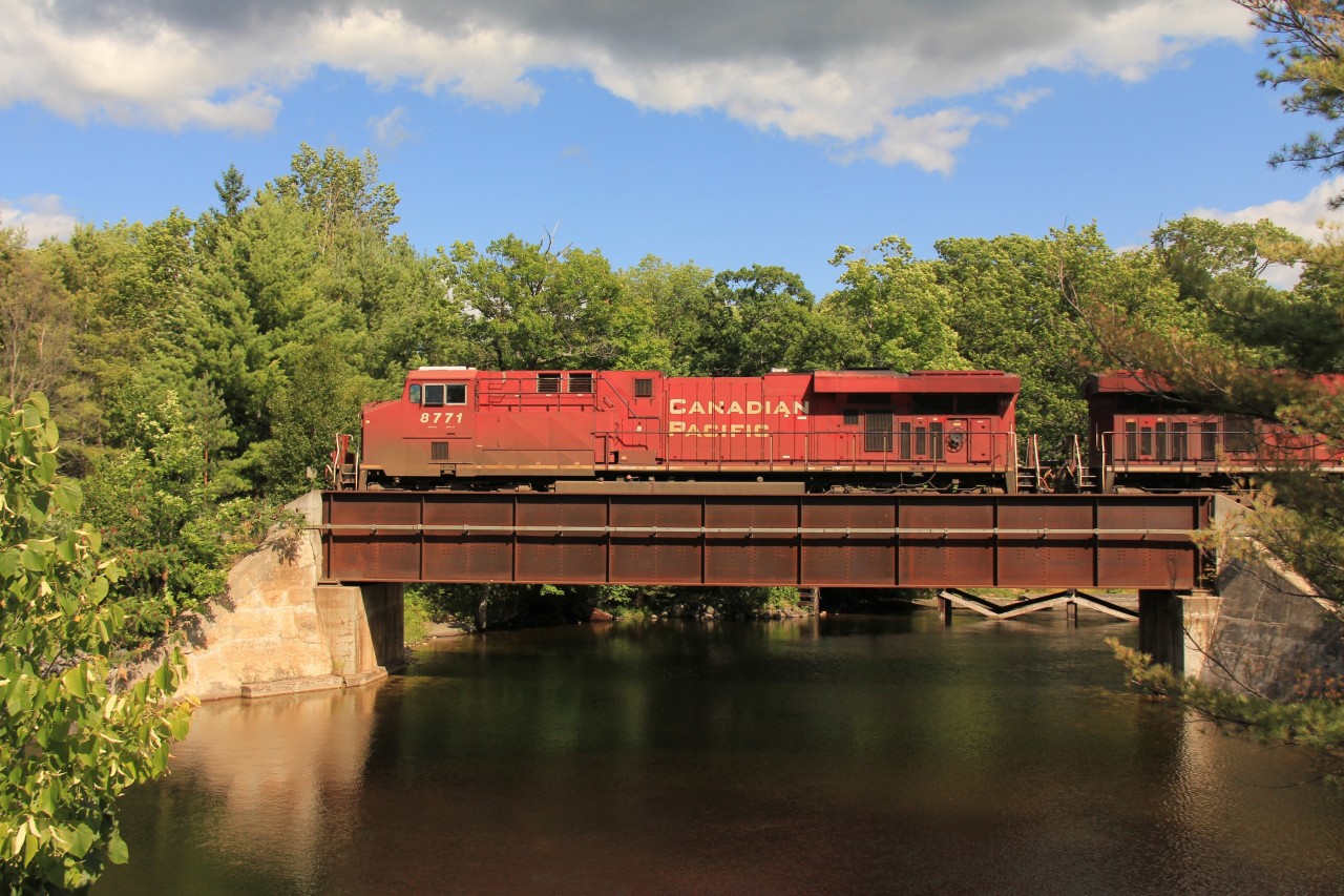 CP 8771 north rolls over one of the three bridges in town that carry the railway over Bala Bay and the famous falls at highest point and start of the Moon River.