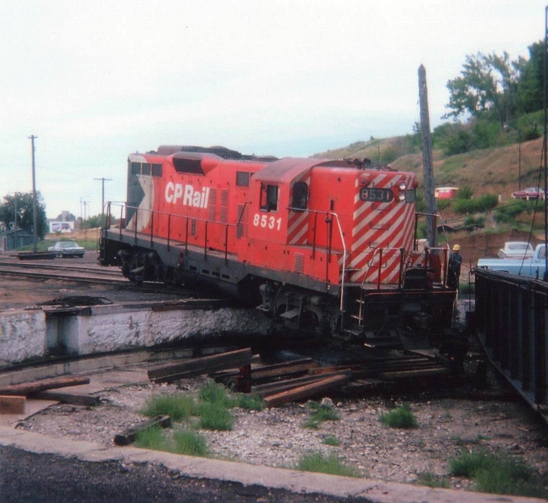Hated starting off saying "This is the Pits" but just couldn't help it. There is a really good story behind this unfortunate incident, but since the person responsible is still working for a railroad, and is in Ontario; I would much rather leave it for him to write and comment on it, rather than attempt to go into detail and mess it up. What I did hear, when one day I met a guy who asked me if I was the one who posted a previous photo on RP regarding this incident, was that back then the one involved had just arrived in Alberta (from Ontario) with a friend, looking for work. He was hired on here at The Hat doing odd jobs in the yard. No sooner than he had gotten the feel of the place, an impatient hogger told him to "move the unit". He said he did not know how, but was talked into trying. And this was the result. It can't be seen in this photo, but the fuel tank was ruptured and it was really pouring out when I went over to have a look at things. Those were the days when a stranger with a camera could wander at will. Hard to believe. I'd love to hear from the unfortunate "potential engineer" if he is still checking photos on this site.  You were what, 19 years old back then? All is forgiven. :o)