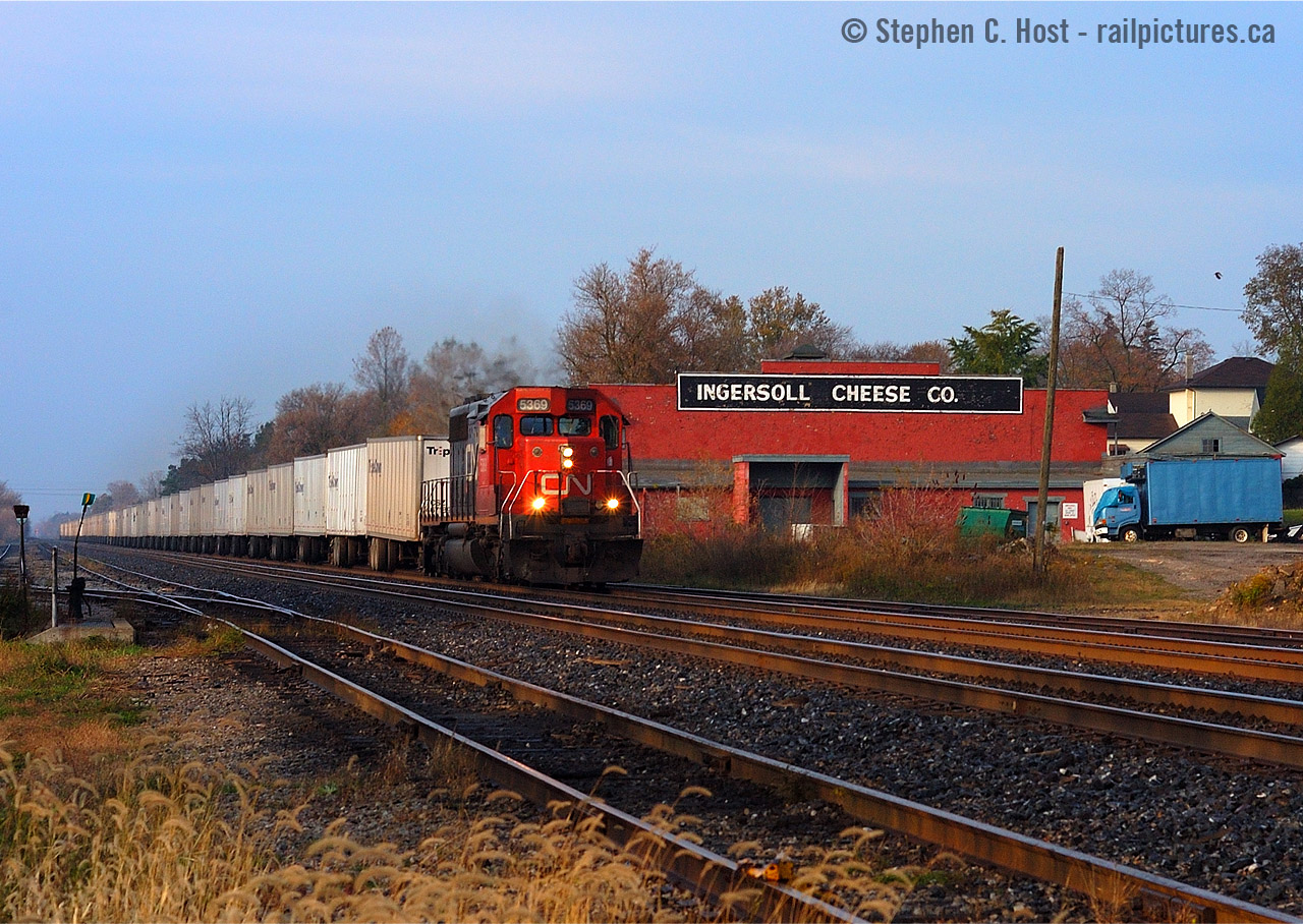 When the cheese factory was still a cheese factory, and when I frowned upon single unit wonders, CN train 144 passes by Ingersoll at 0857 on a beauty October morning. I do not frown upon this photo anymore. Photo notes: one of my few photos taken with the Nikon D100, Nikkor 50mm f/1.8 at f/6.3 1/1250 ISO 200. I can't believe how primitive this 6 megapixel digital SLR camera was, and still is.. I used it for a week or two while my D70 was in the shop. All photos from this camera MUST be edited, nothing really comes out 'ready to go' without significant in-camera fiddling (curves, etc). How times have changed..