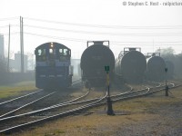 In a scene reminiscent of a bygone era, a lone headlight lights the way on SW1200 #1007 as they switch cars on a foggy morning in Sarnia, Ontario.