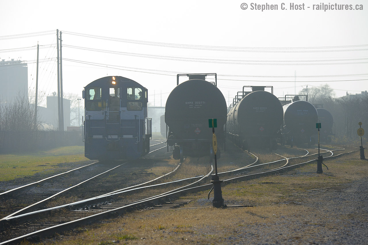 In a scene reminiscent of a bygone era, a lone headlight lights the way on SW1200 #1007 as they switch cars on a foggy morning in Sarnia, Ontario.