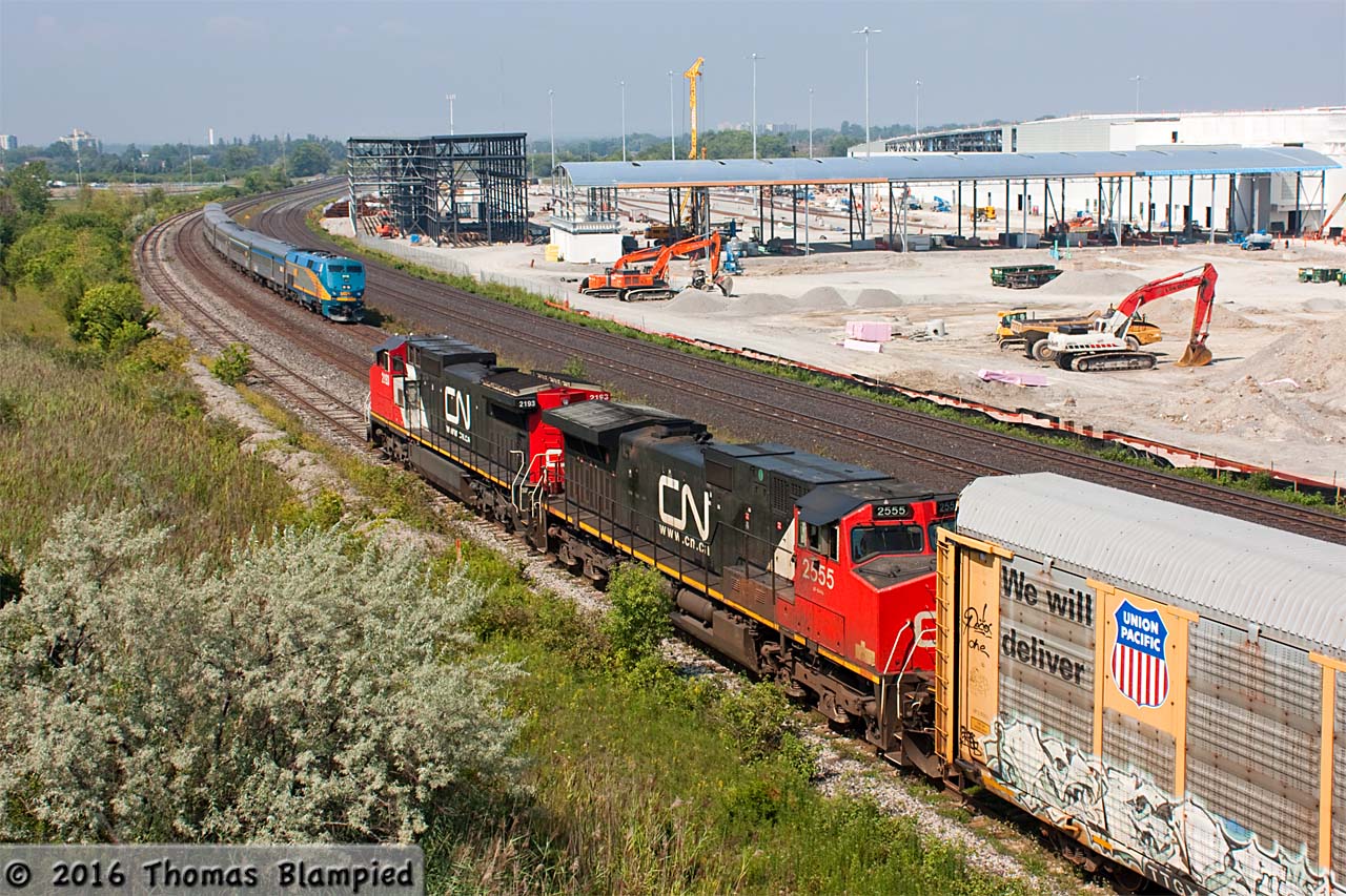 A nice meet and a nice excuse to talk about the continuing construction on GO Transit's new east maintenance facility. Firstly, this shot wraps up an unusually busy morning in the Whitby/Oshawa area, which saw two westbound freights working Oshawa Yard simultaneously (one on the main, and this one on the yard lead). As CN 2193 and 2555 prepare to depart with an unknown train (I suspect it is either 369 or 373), VIA 918 rolls past with train 64 and an all-Budd consist. In the background, construction of more sheds has begun and is beginning to obstruct the view from the Hopkins Street bridge. To the east, work continues on more structures. Currently, Hopkins is reduced to one lane with deep trenches being dug in the road. While the days of this location are undoubtedly numbered, there is still no sign of when the road will close.