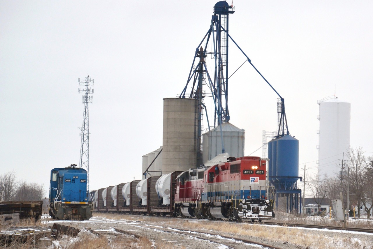 RLK 4057 and stable-mate NECR 3840 slowly climb upgrade  past the then idle elevators through Hagersville with one of several wind turbine trains destined for SOR's Franklin Yard further south near Nanticoke, ON.  Franklin Yard is located on the US Steel spur just off of Concession 3 and served as a temporary, convenient trans load site for local wind turbine units rail to truck.  CEFX 2019 sits parked for the moment on siding HD 34. 

Additionally I would like to enter this photo into the 'Time Machine' challenge as a companion photo to my 2011 photo http://www.railpictures.ca/?attachment_id=26075 and moreover partnered with the original photo submitted by John Eull http://www.railpictures.ca/?attachment_id=4863 of 1986.  The office / depot was smoked between photos and the water tower repainted white with a blue base.  The 'Time Machine' challenge provides an opportune and interesting comparison.