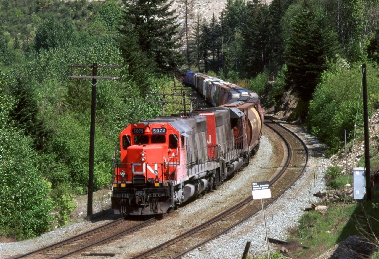 My notes say that this is at Martinson, but I do not know for certain. It might be at Boston Bar.
Anyway, this is a loaded grain train as it approaches Boston Bar. The units look like they were in aggregate service recently.