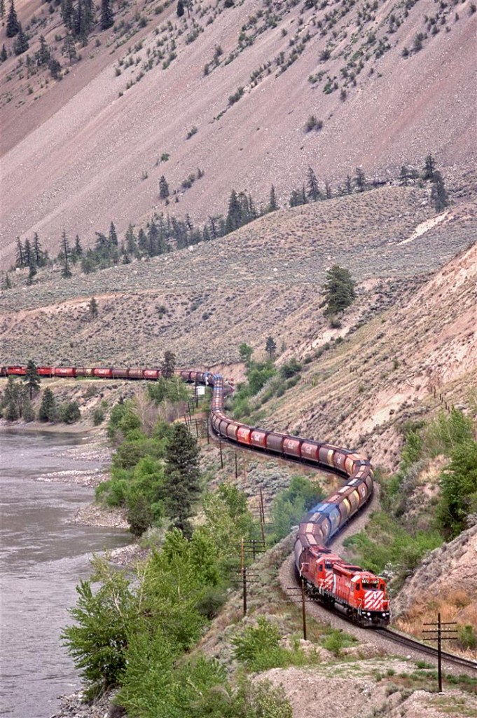 A CP grain train headed for Vancouver is approaching Spences Bridge. It is strange to have only two locomotives up front, but two mid-train units can also be seen.