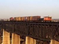 A "Clover Bar Transfer" (one of many during the day) is returning to Calder/Walker Yard. It is crossing the high bridge over the North Saskatchewan River in NE Edmonton. The style of caboose used on the transfer and switch movements was typical.