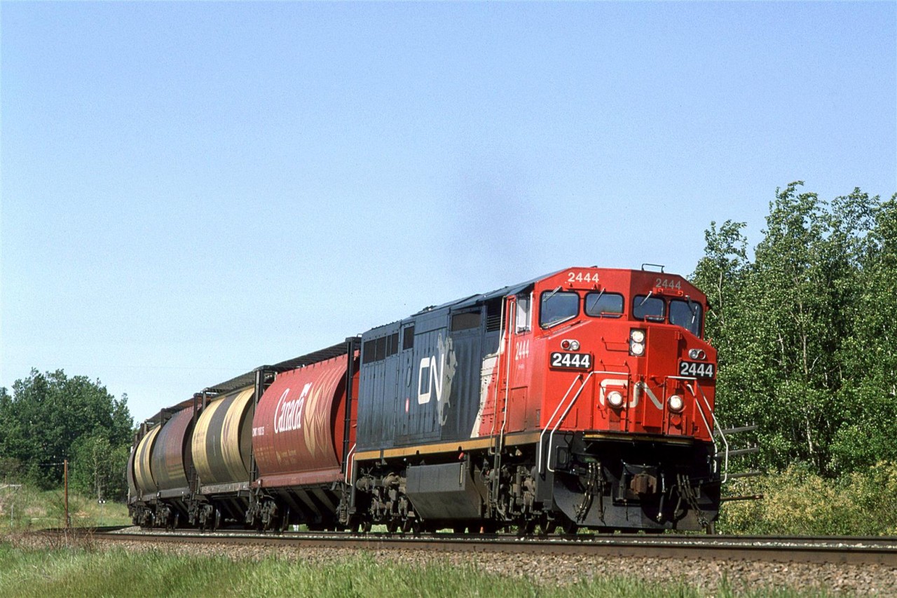 An empty grain train swings through the first curve at Carvel. It is running on the north track because there is a westbound grain on the south track.
