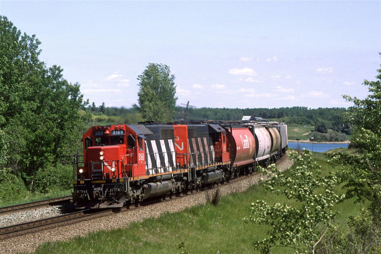 This is a westbound grain train on the south track through the two big bends at Carvel. Mink Lake can be seen at right.