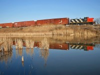 CN 1422 reflects in the duck pond on the north side of Oakville Yard as it shoves parts cars up into the Ford complex back in the spring of 2007. 