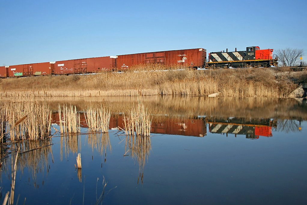 CN 1422 reflects in the duck pond on the north side of Oakville Yard as it shoves parts cars up into the Ford complex back in the spring of 2007.