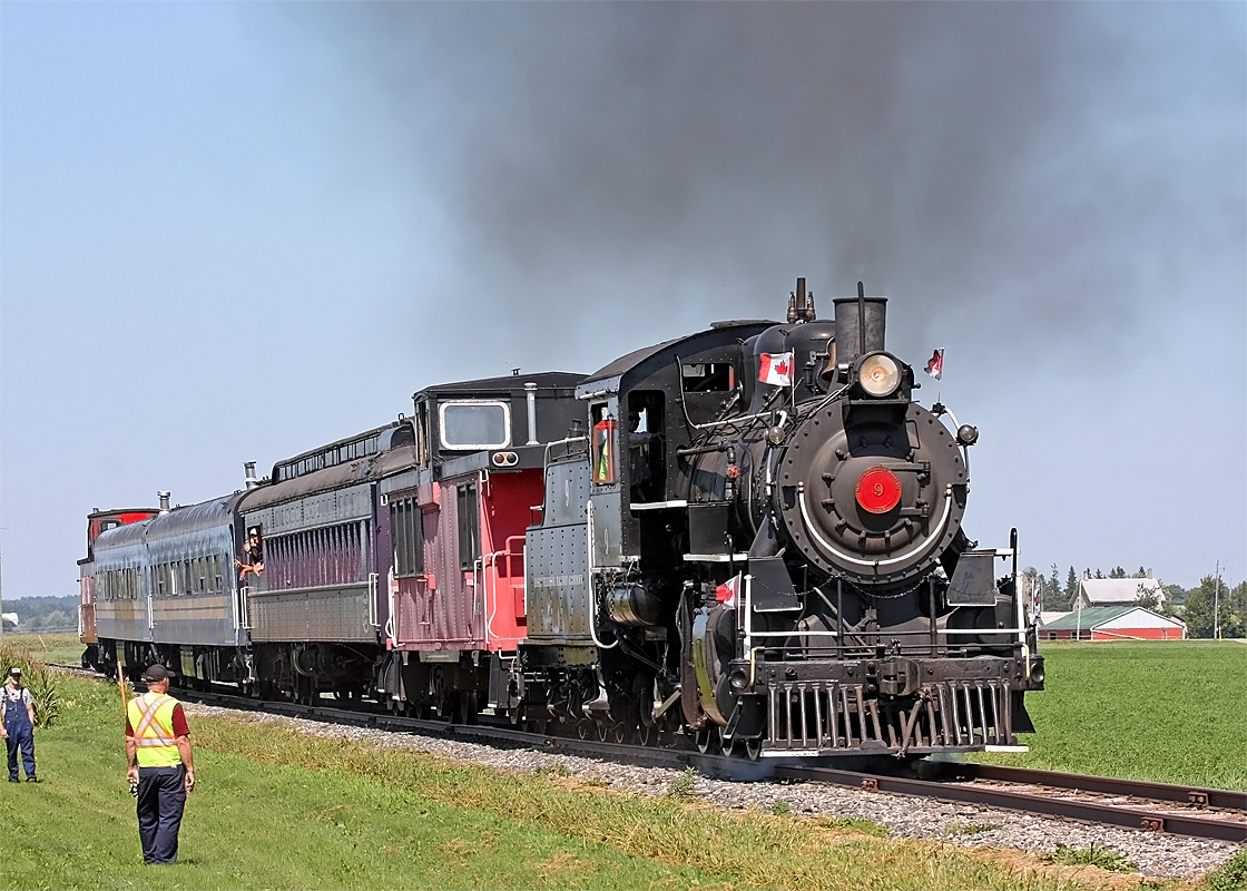 Riding the Waterloo Central steam excursion train is a great way to spend family time and introduce the kiddies to the heritage of bygone days, but for the advanced rail photographers their hyped photo run-by can be a major disappointment. There is obviously just no place in a "heritage" type image for a fluorescent safety vest! I understand the need for safe crowd management in this type of situation, but the volunteers at the south end of the photo line were quite capable of achieving just that without standing 20 feet out in front like these two felt was necessary. Of course with the train approaching from the north this put them right in the line of photographic fire, thereby ruining pretty much everyone's shots. My recommendation would be to just chase and photograph the train while supporting their endeavors with a donation instead of riding, and leave the ticket sales to the cell-phone crowd. My only half-decent shots were taken after the ride when the train was dead-heading back to St. Jacobs, except for the plume flowing the wrong direction when there was a plume. Oh, and at this time of year perhaps (if possible) running the excursion an hour later would put the sun less head-on and light the side of the loco a bit better - just sayin'. I have to admit I debated whether or not to submit this shot at all, but I feel those planning on driving a long distance like we did would appreciate knowing what they would be up against.