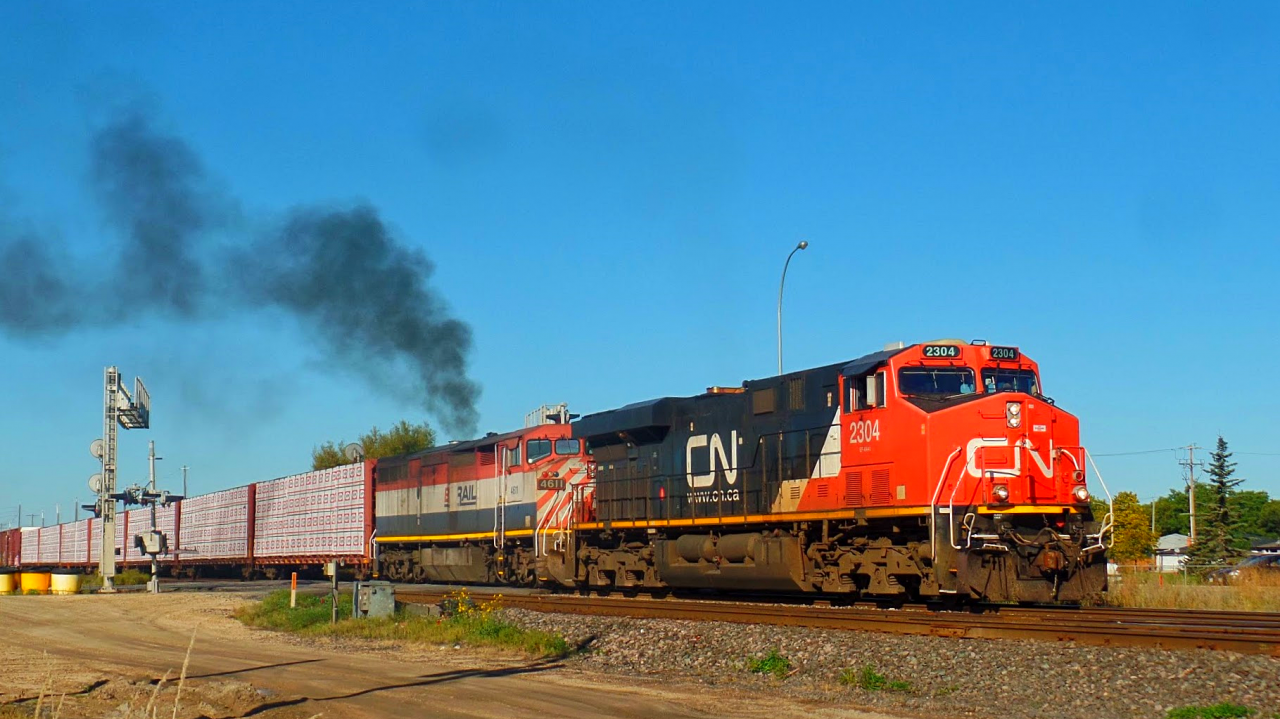 This long CN freight mostly made up of lumber continues it's journey east on the CN Rivers Subdivision, as BCOL 4611 smokes it up trying to help get the train moving.