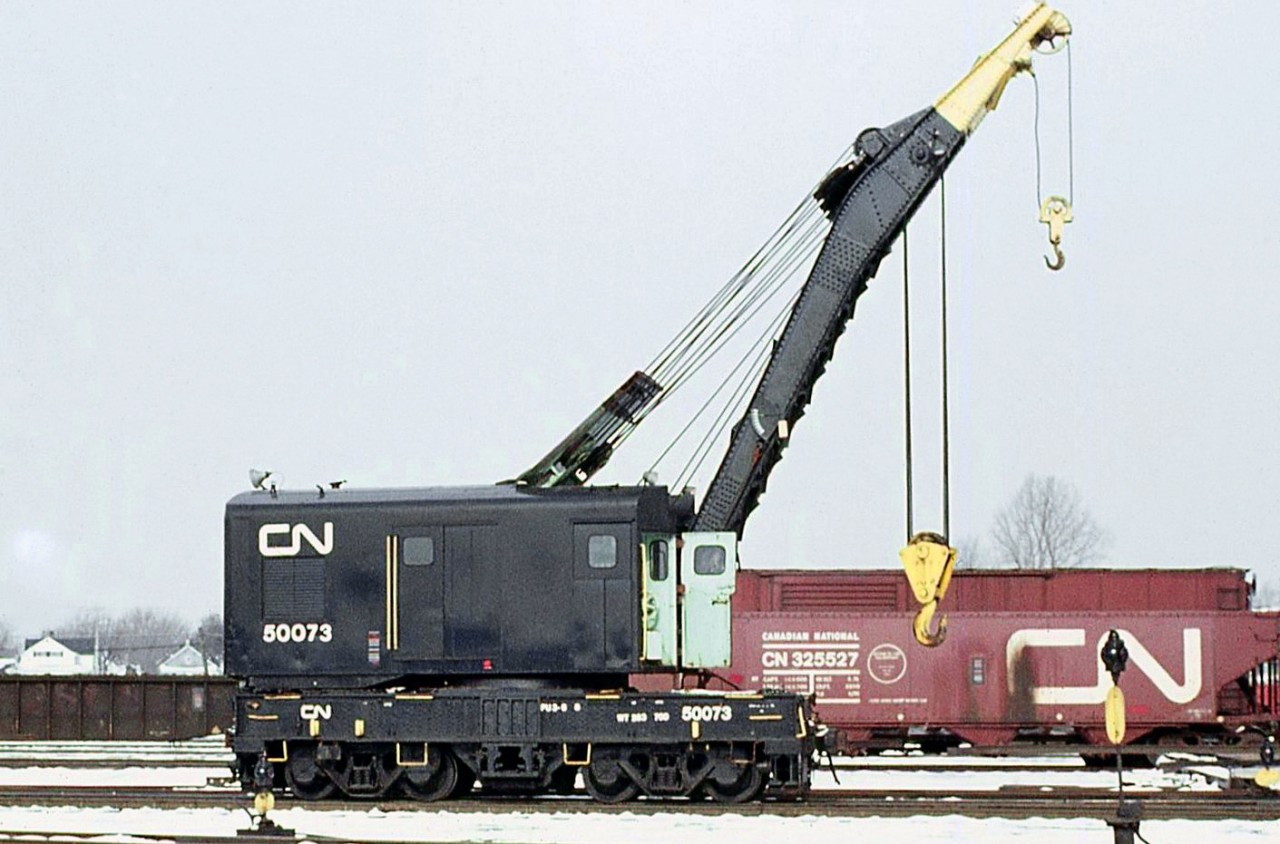 Canadian National "Big Hook" 50073 (a 1920 Industrial Works 120-ton crane) is shown at CN's yard in Fort Erie back on February 9th, 1973. 

Often times before the era of contractor cleanup services, the larger railways had wreck auxiliary trains based out of strategic locations or major divisional points on the system for clearing up derailments. They usually contained a "big hook" suitable for lifting large mainline locomotives that might need rerailing.