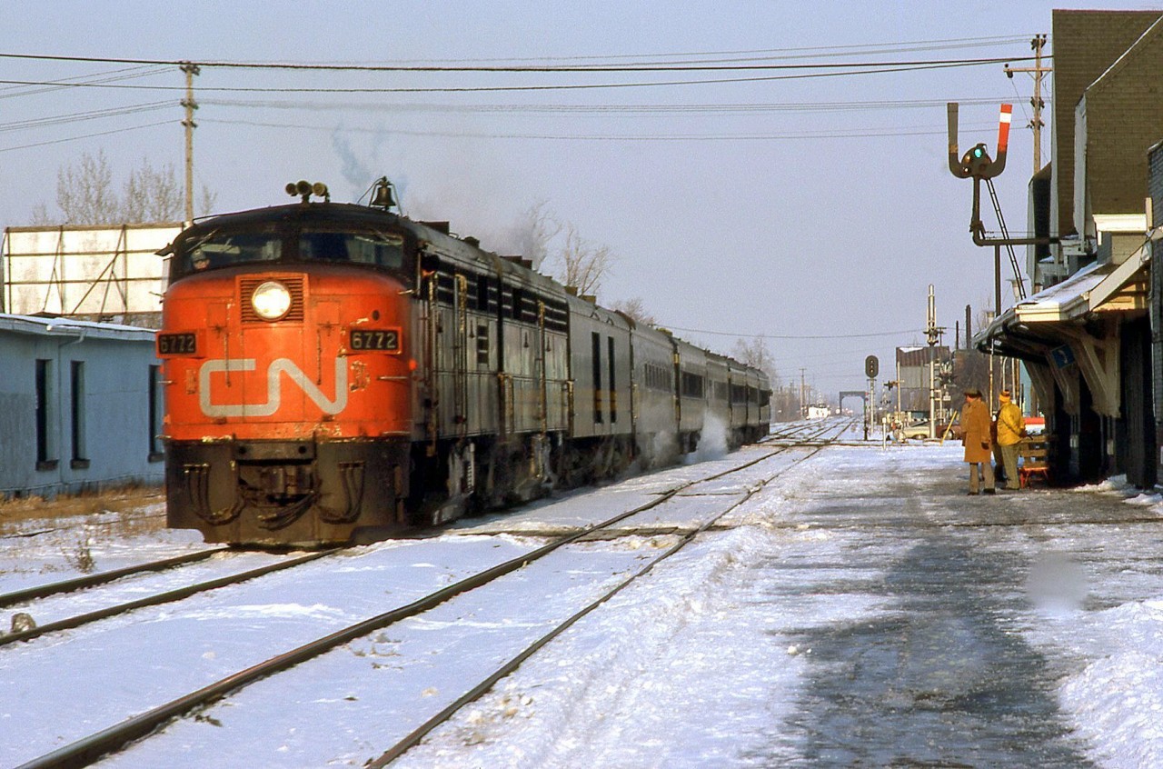 VIA train #75 arrives at Chatham station, behind CN-painted FPA4 6772 (still with its CN noodle on the nose, and not yet repainted for VIA). In the distance is the crossing with the C&O Sub 2, and the large steel bridge crossing McGregor Creek.