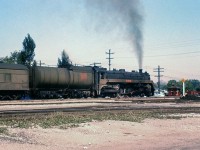 Canadian National 4-6-4 Hudson 5700 handles an eastbound passenger train through Port Credit, just about to cross the Highway 10 grade crossing on the Oakville Sub. The spur in the foreground crossed Highway 10 and lead south to the St. Lawrence Starch Company (it was later re-aligned to come off the Oakville Sub from the east due to underpass construction a few years later).
<br><br>
<i><b>More at Port Credit:</i></b><br>
Hwy 10 underpass construction in 1963: <a href=http://www.railpictures.ca/?attachment_id=21410><b>http://www.railpictures.ca/?attachment_id=21410</b></a><br>
CNR 6070 at speed: <a href=http://www.railpictures.ca/?attachment_id=24345><b>http://www.railpictures.ca/?attachment_id=24345</b></a>